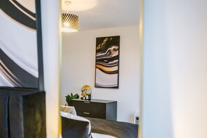A modern bedroom with a bed, a nightstand, a desk, and a pendant light. - 2BDR | Free Parking | Stylish Liverpool Apartment (Liverpool)