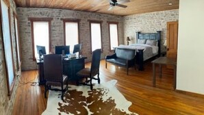 Ein Schlafzimmer mit einem Bett, einem Schreibtisch mit Computer und einem Cowhide-Teppich.