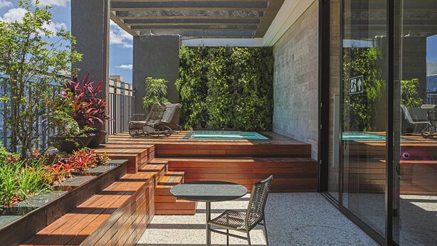 Une terrasse sur le toit avec une piscine, des sièges en bois et des plantes en pot.