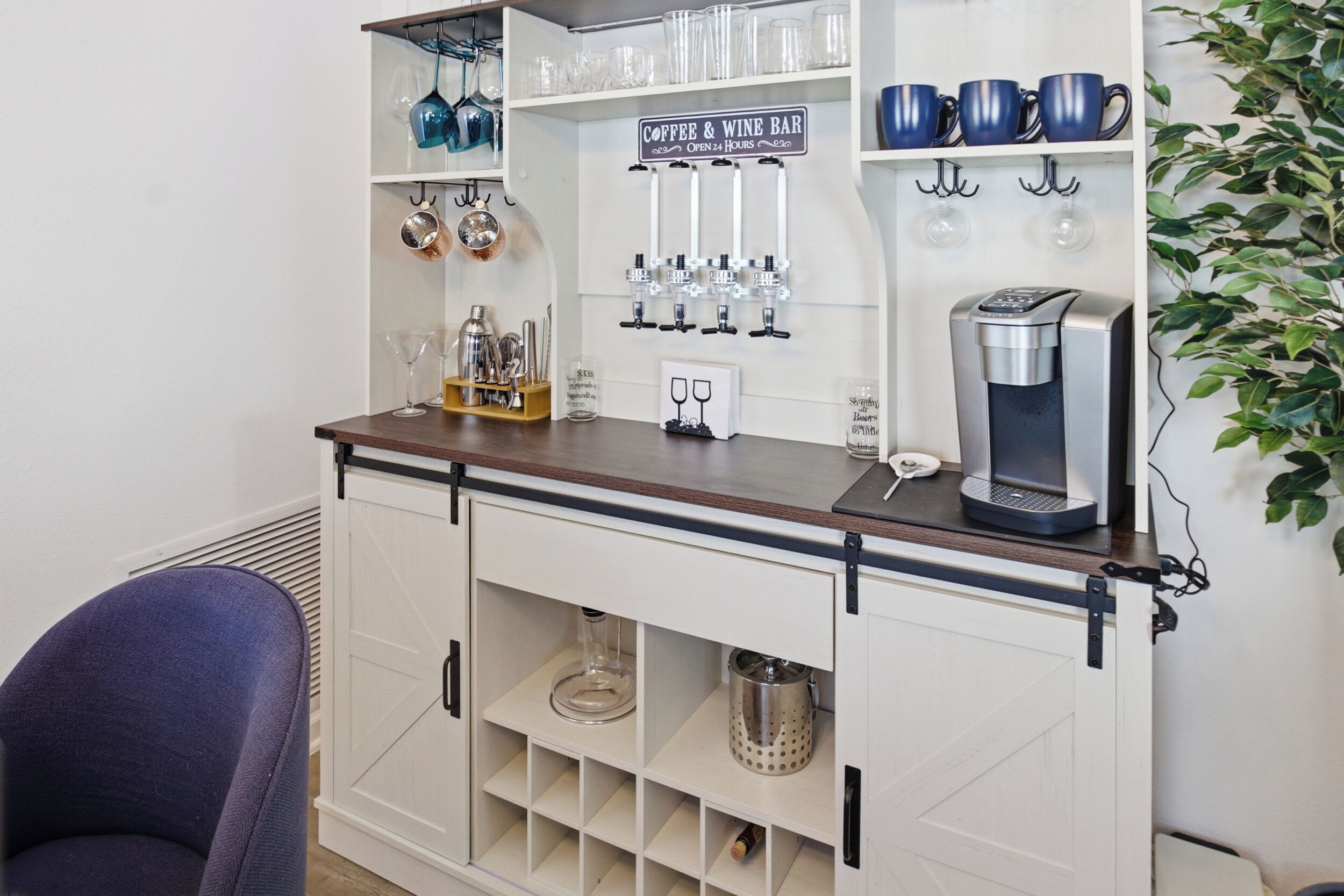 A bar area with a coffee machine, wine glasses, and a sign indicating it's a coffee and wine bar open 24 hours.