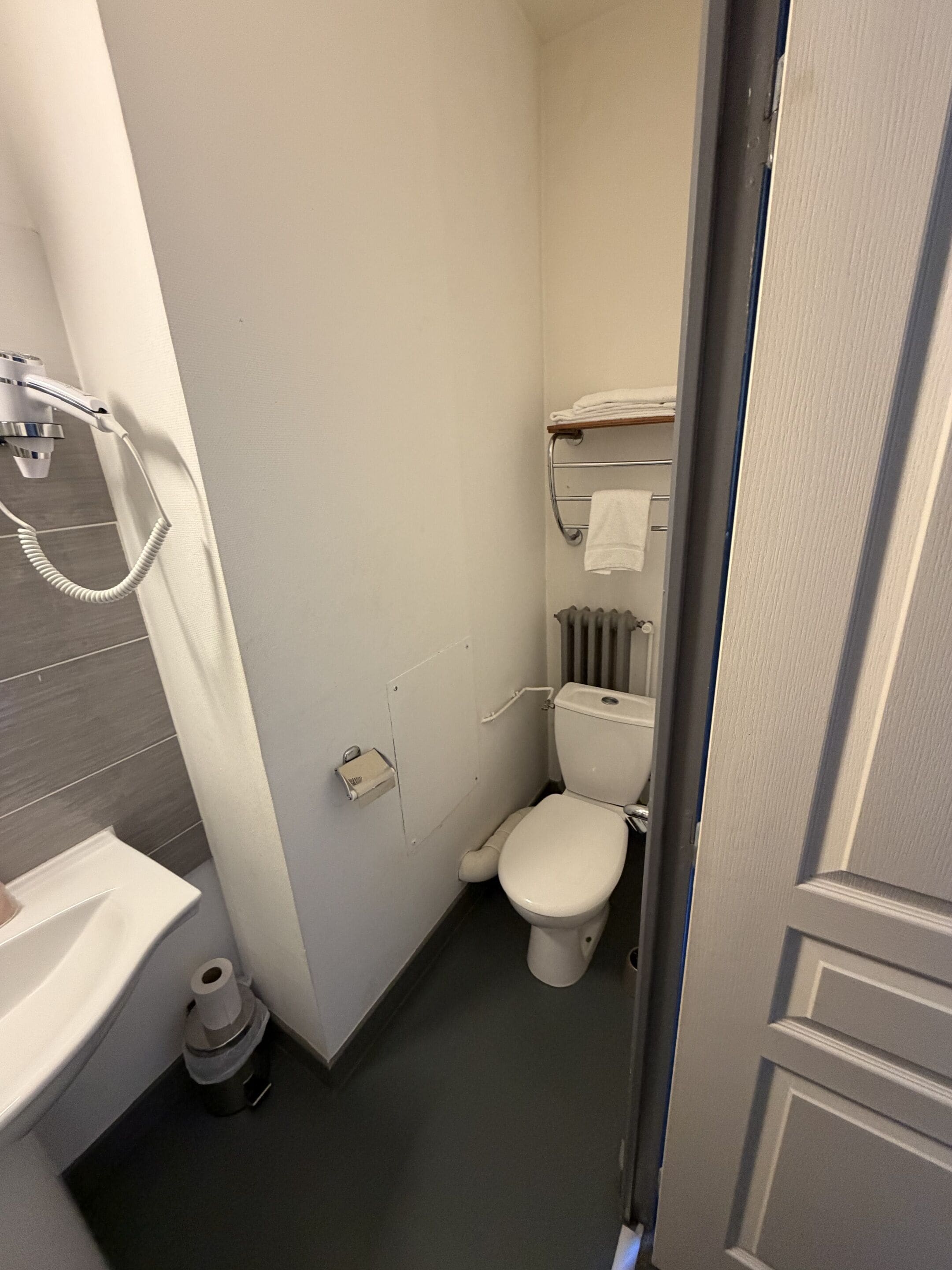 A compact bathroom with a toilet, a sink, and a shower.