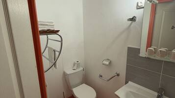 A small bathroom with a toilet, sink, and towel rack.