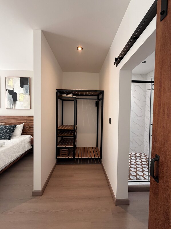 Une chambre moderne avec un lit superposé, un plancher en bois et un espace douche agrémenté de carreaux décoratifs.