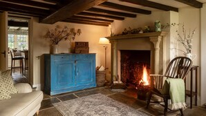 Ein gemütliches Wohnzimmer mit Kamin, einem blauen Schrank und einem gemusterten Teppich.