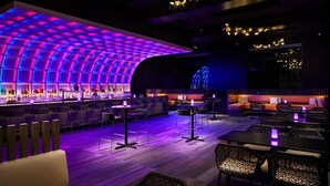 A modern bar area with a curved ceiling and ambient lighting.
