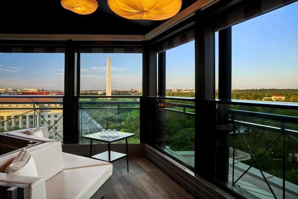 A modern balcony with a view of a city skyline, including a prominent monument.