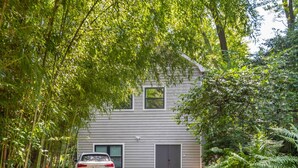 Une maison à deux étages avec une voiture garée devant.