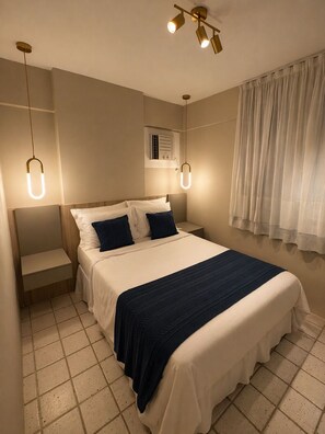A bedroom with a bed, bedside tables, a ceiling light fixture, and a window with curtains. - Apê Av. Boa Viagem Praia & restaurantes (Recife)