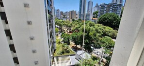 A high-rise building with multiple air conditioning units, a view of a tree-lined street, and surrounding high-rise buildings. - COBAR0147 - Edificio Beira Valle (Salvador)