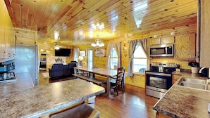 A cabin interior with a kitchen, dining area, and living space. - Bluff Mountain Vista (Sevierville)