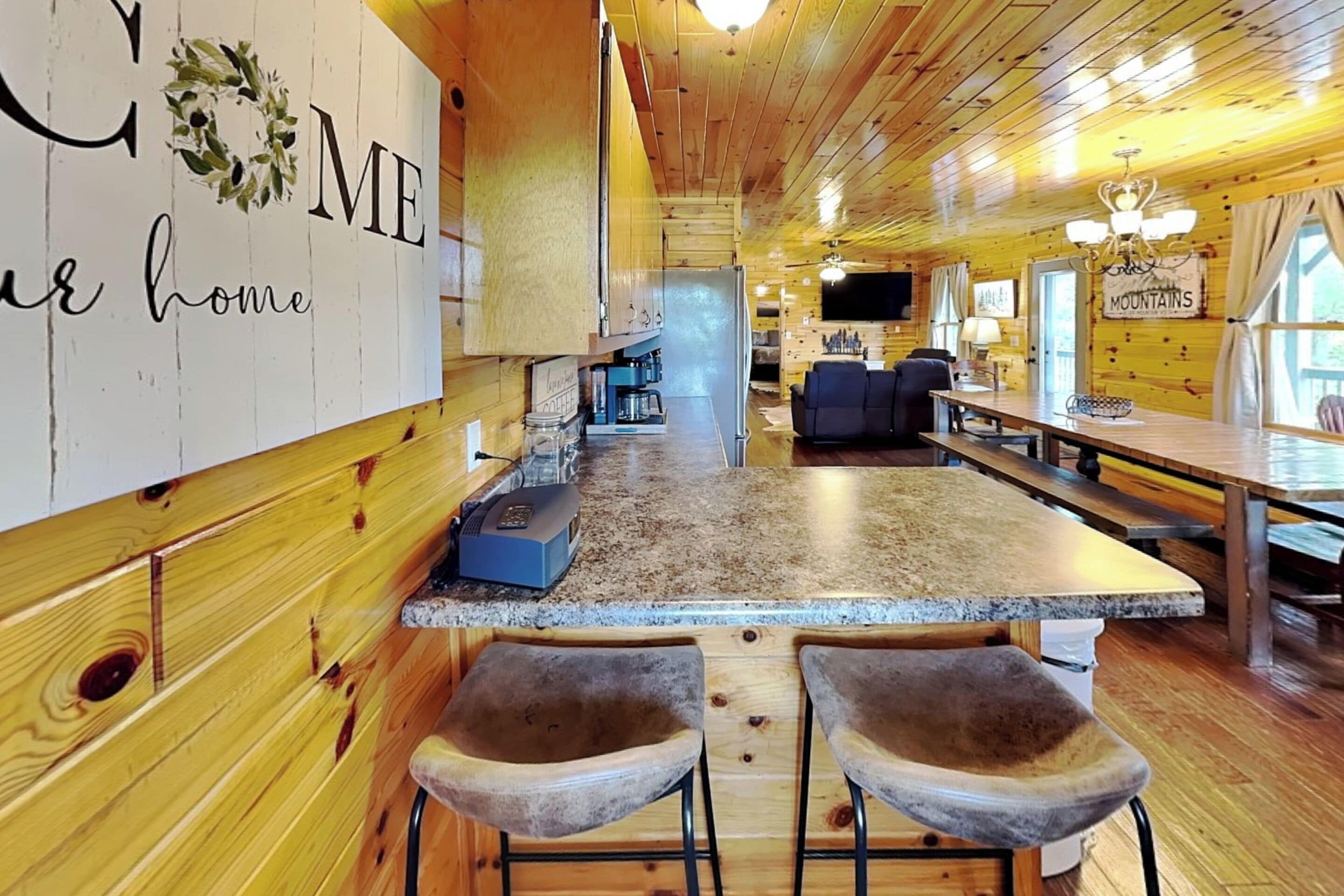 A cozy cabin interior with a kitchen, bar area, and seating space.