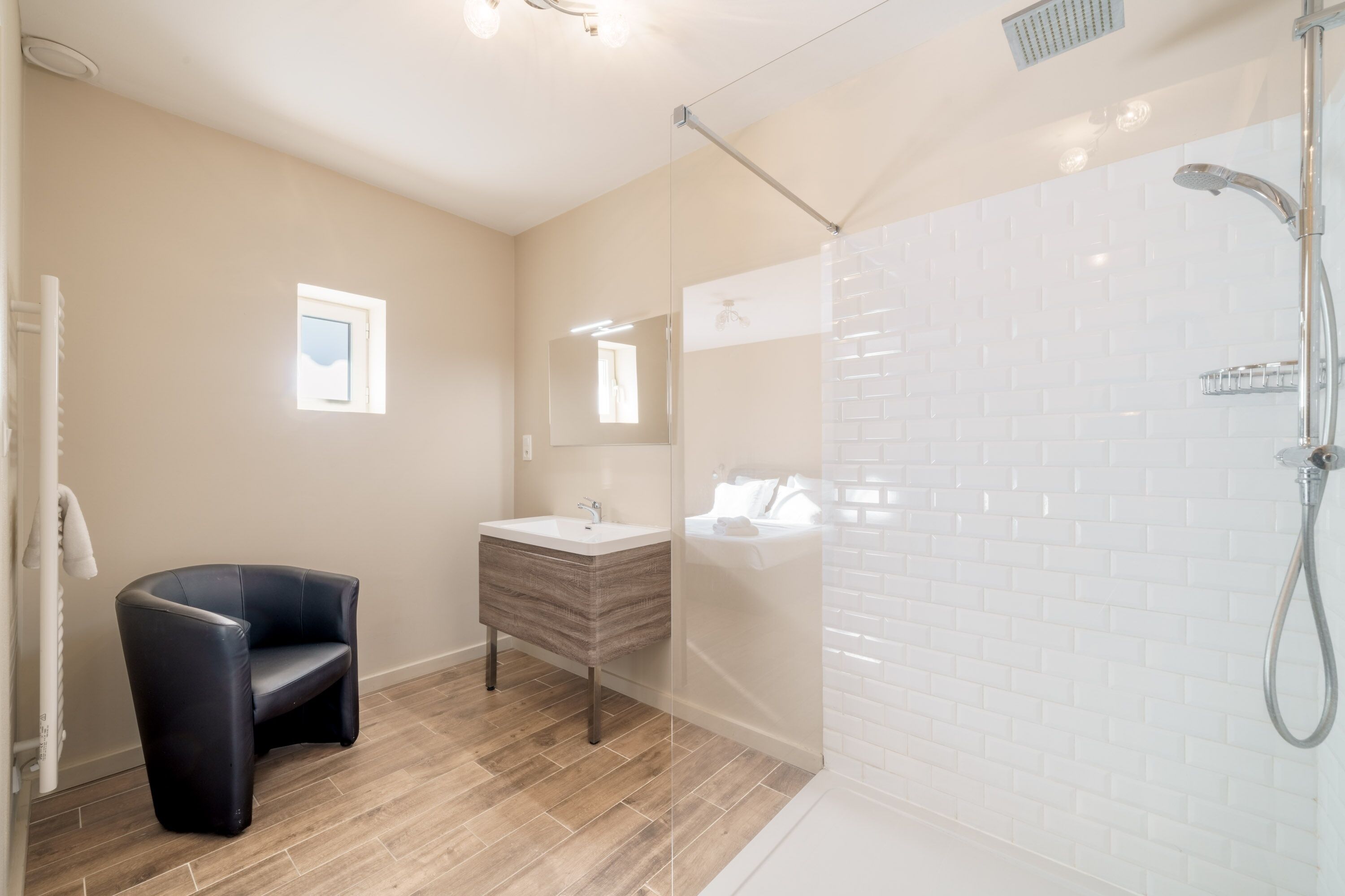 Een moderne badkamer met een douche, een wastafel en een zithoek.