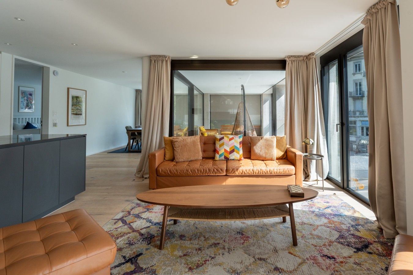 Una sala moderna con sofá, una mesa de centro y vistas a través de un ventanal.