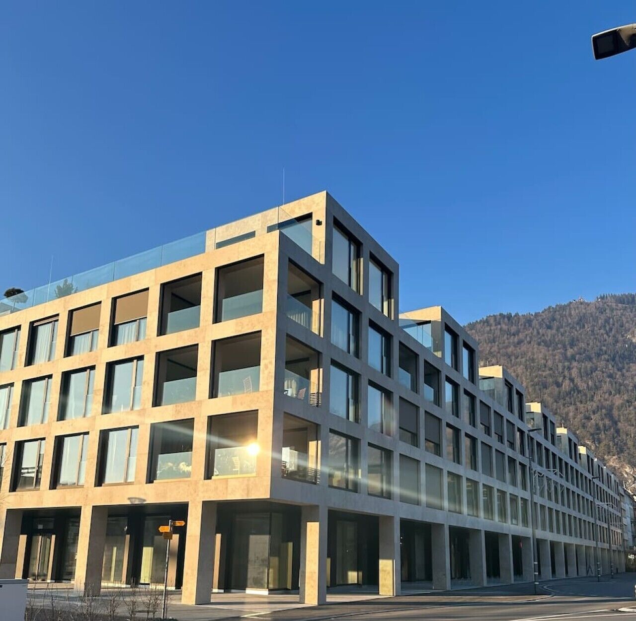 Un immeuble moderne à plusieurs étages, doté d’un toit plat et de grandes fenêtres.