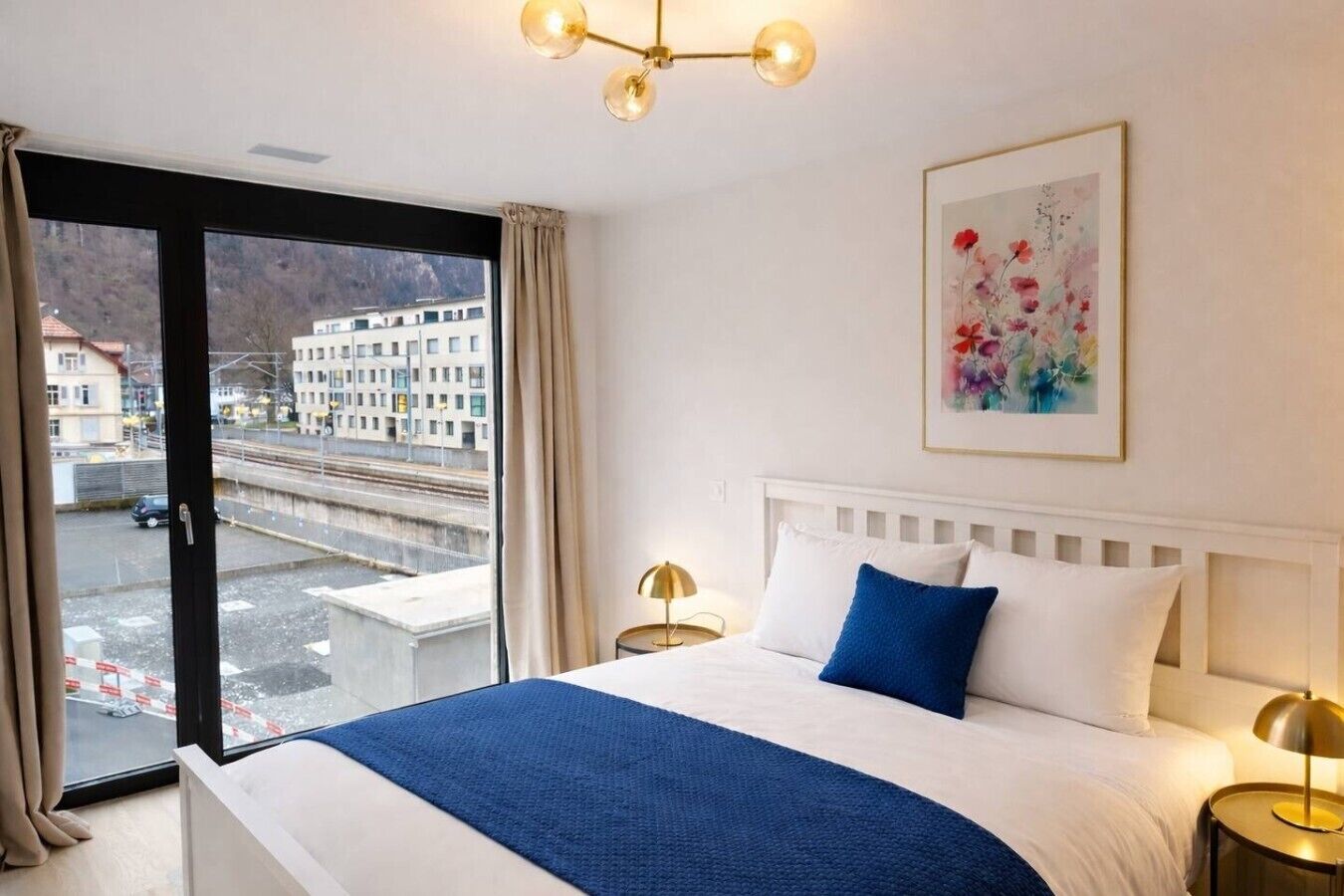 Una habitación de hotel con una cama, vista a la ciudad y un cuadro en la pared.