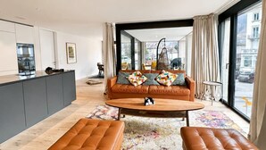 Un salon moderne avec un canapé, une table basse et un pouf.