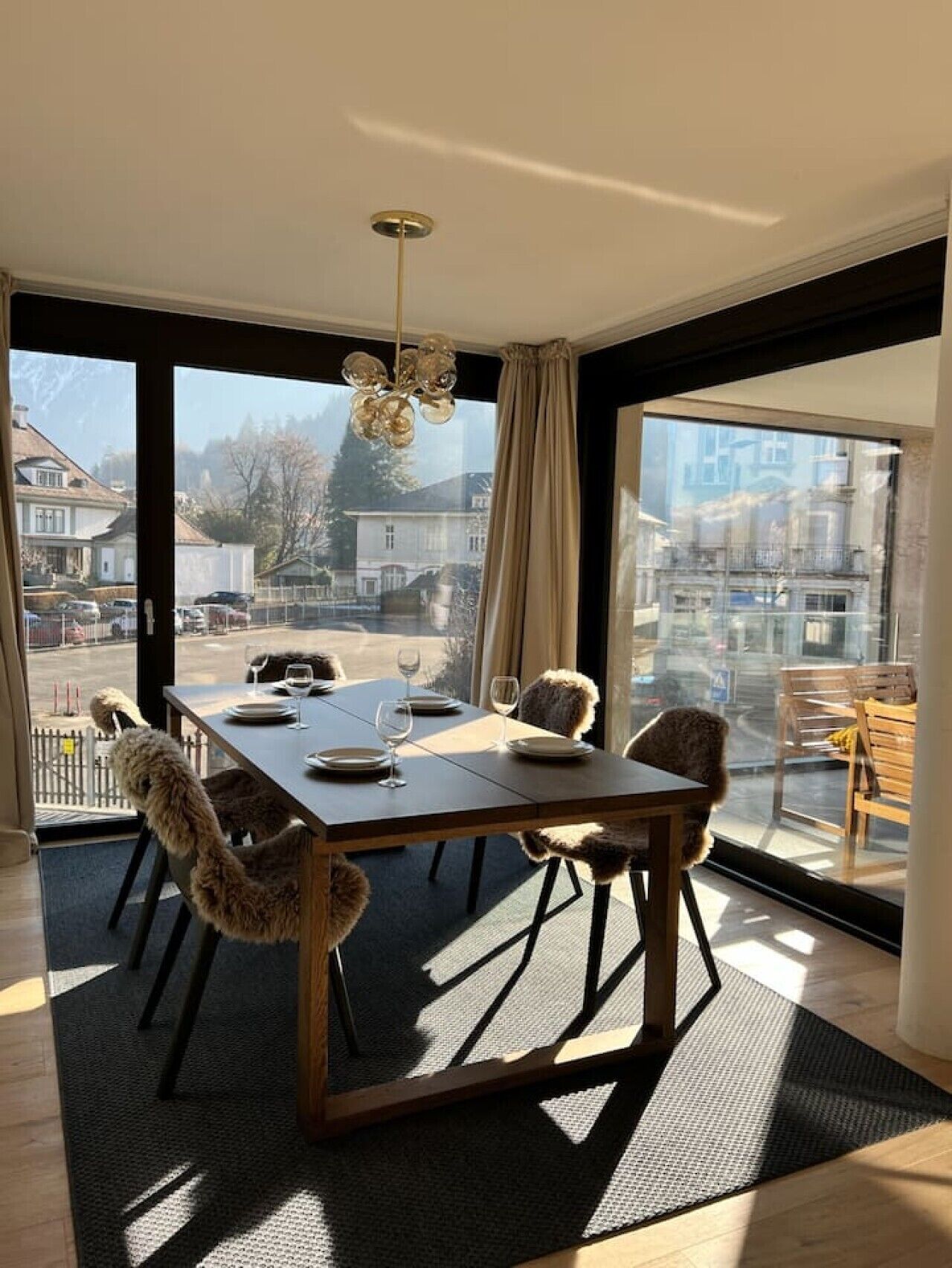 Een eetgedeelte met een tafel voor vier personen, grote ramen en uitzicht op het omliggende landschap.