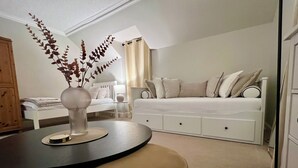 Un dormitori modern amb un llit, una taula de nit i una planta decorativa.