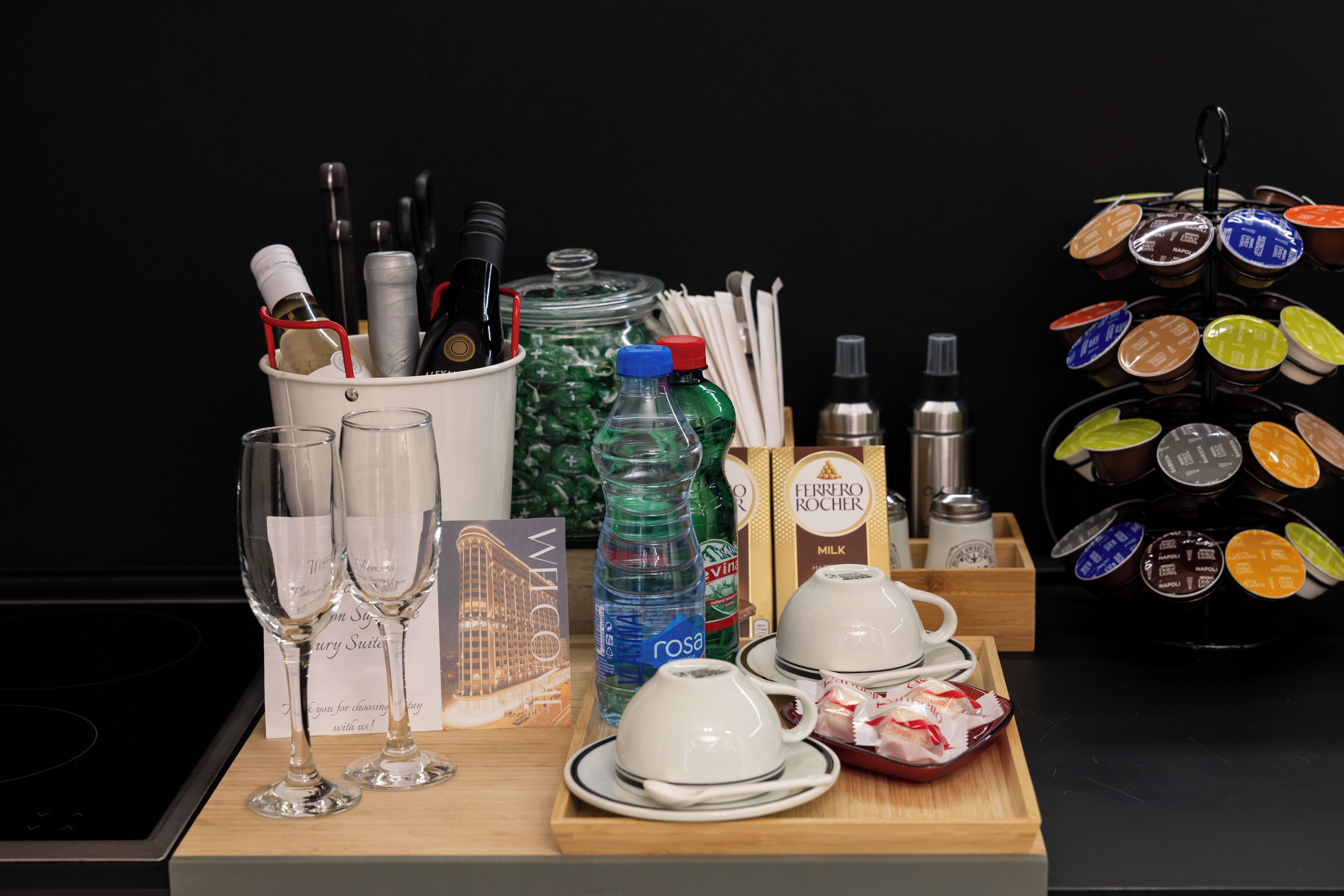 A tray with wine glasses, a bottle of rosé, a bottle of milk, and a coffee machine.