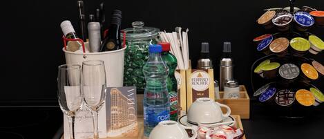 A tray with wine glasses, a bottle of rosé, a bottle of milk, and a coffee machine.