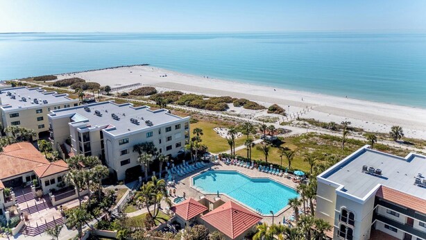 Ein Resort mit Pool, Blick auf den Strand und mehreren Gebäuden.