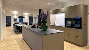 Una cocina moderna con una isla central, electrodomésticos integrados y una zona de comedor con vistas.