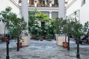 A courtyard with potted plants and columns. - Lady Rose One - One Bedroom Apartment, Sleeps 4 (Naples)