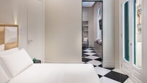 A hotel room with a bed, a door leading to a hallway, and a checkered floor. - Lady Rose One - One Bedroom Apartment, Sleeps 4 (Naples)