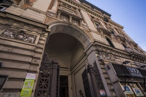 Fachada de edifício ornamentada com detalhes arquitetônicos clássicos, incluindo colunas e molduras decorativas.