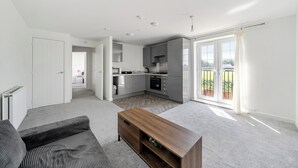 En moderne lejlighed med stue, køkken og balkon.