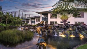 Een resort met een vijver, waterval en sculpturen van dolfijnen.