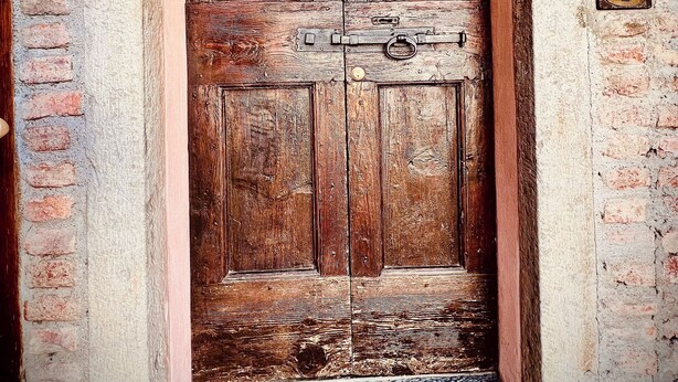 Una puerta de madera con un letrero que dice "Bienvenido a nuestro Airbnb".