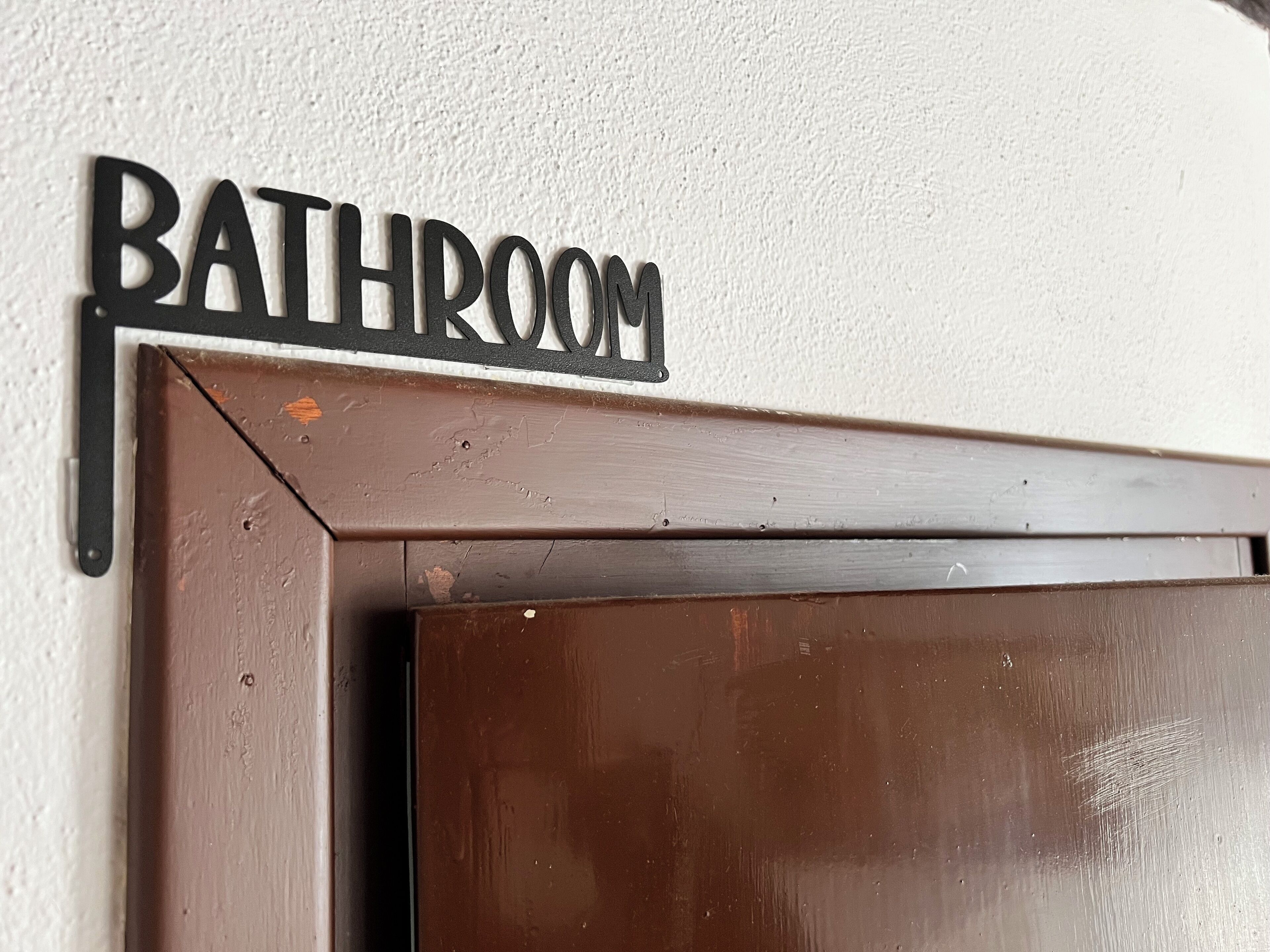 Un letrero de baño en una pared.