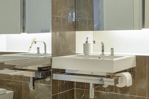 Ein modernes Badezimmer mit zwei Waschbecken, einem Spiegel und einer Toilette.