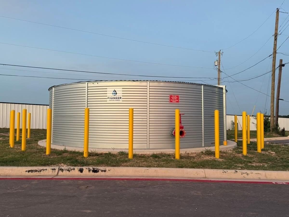 Ein zylindrischer Metallwassertank mit dem Schriftzug 'Pioneer Water Tanks'.