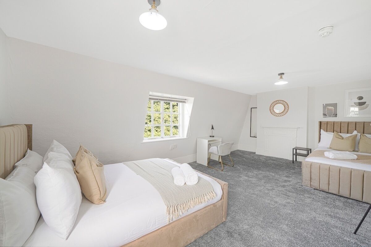 A bedroom with a bed, a desk, and a chair.