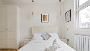 A bedroom with a bed, white walls, a window, and a radiator. - 1 Bedroom Center London Luxury Pad, High Spec (Greater London)