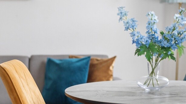 A modern living room with a sofa, a round table, and a vase of flowers. - 1 Bedroom Center London Luxury Pad, High Spec (Greater London)