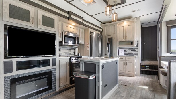 A modern kitchen with a flat-screen TV, stainless steel appliances, and a central island. - Joy Drive In Movie & RV Resort - Montana - Joy Drive In Movie & RV Resort - Montana (Copperas Cove)