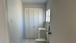 Une salle de bain avec des toilettes, un lavabo et une porte fermée.