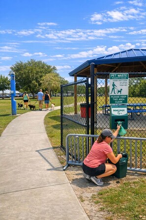 A dog waste station with a sign warning about pet waste and a dog pot.