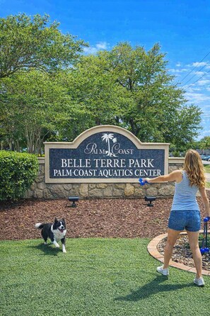 Une signalisation indiquant le parc Belle Terre, le centre aquatique de Palm Coast, avec un chien et une personne.