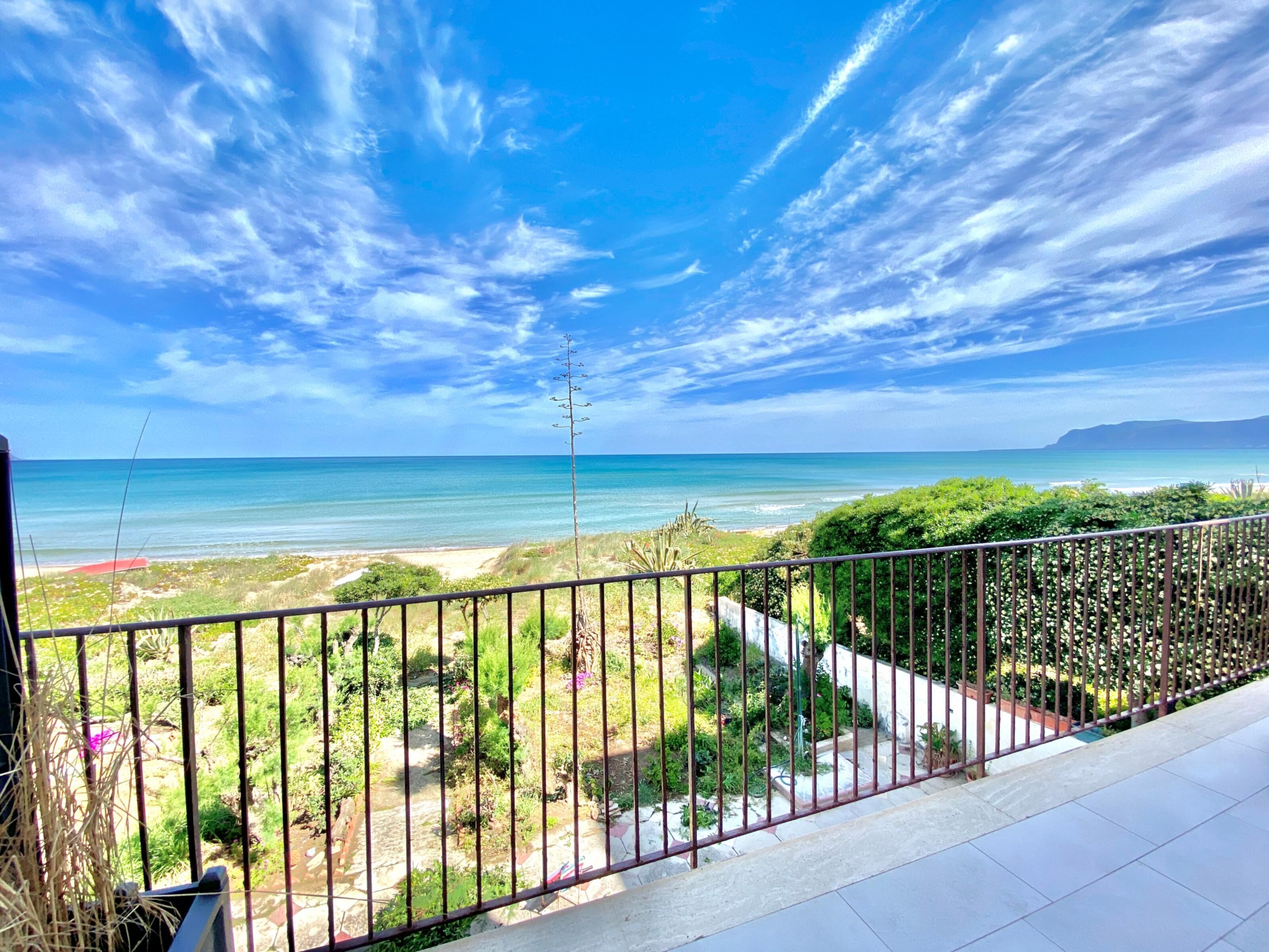 A balcony with a view of a beach and ocean.