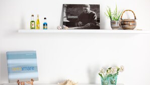Zwei Regale mit verschiedenen Gegenständen, darunter Bücher, Flaschen und Dekorationsobjekten.