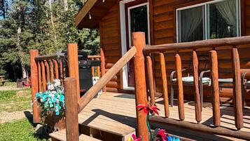 Une cabane en bois avec une véranda, des marches et une fenêtre.