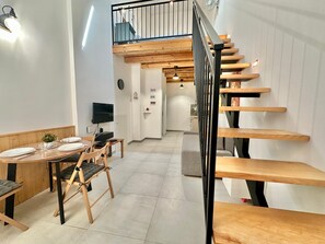 A modern interior with a dining area, a staircase, and a kitchen. - Loft Pergola, prime location (CASTELLAMMARE DEL GOLFO)