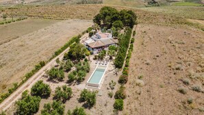 An aerial view of a property with a swimming pool, a house, and surrounding vegetation. - Villa Adele Alcamo, private pool and privacy (ALCAMO)