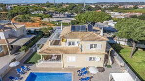 A residential building with a swimming pool, solar panels, and a view of the surrounding neighborhood. - Villa Caly by Villa Plus (Olhos de Água)