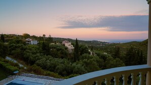 Ein Pool mit Blick auf eine Hügellandschaft und Gebäude in der Ferne.