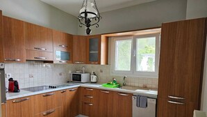 Eine Küche mit Holzausstattung, einer Mikrowelle, einem Wasserkocher und einem Fenster mit Blick.
